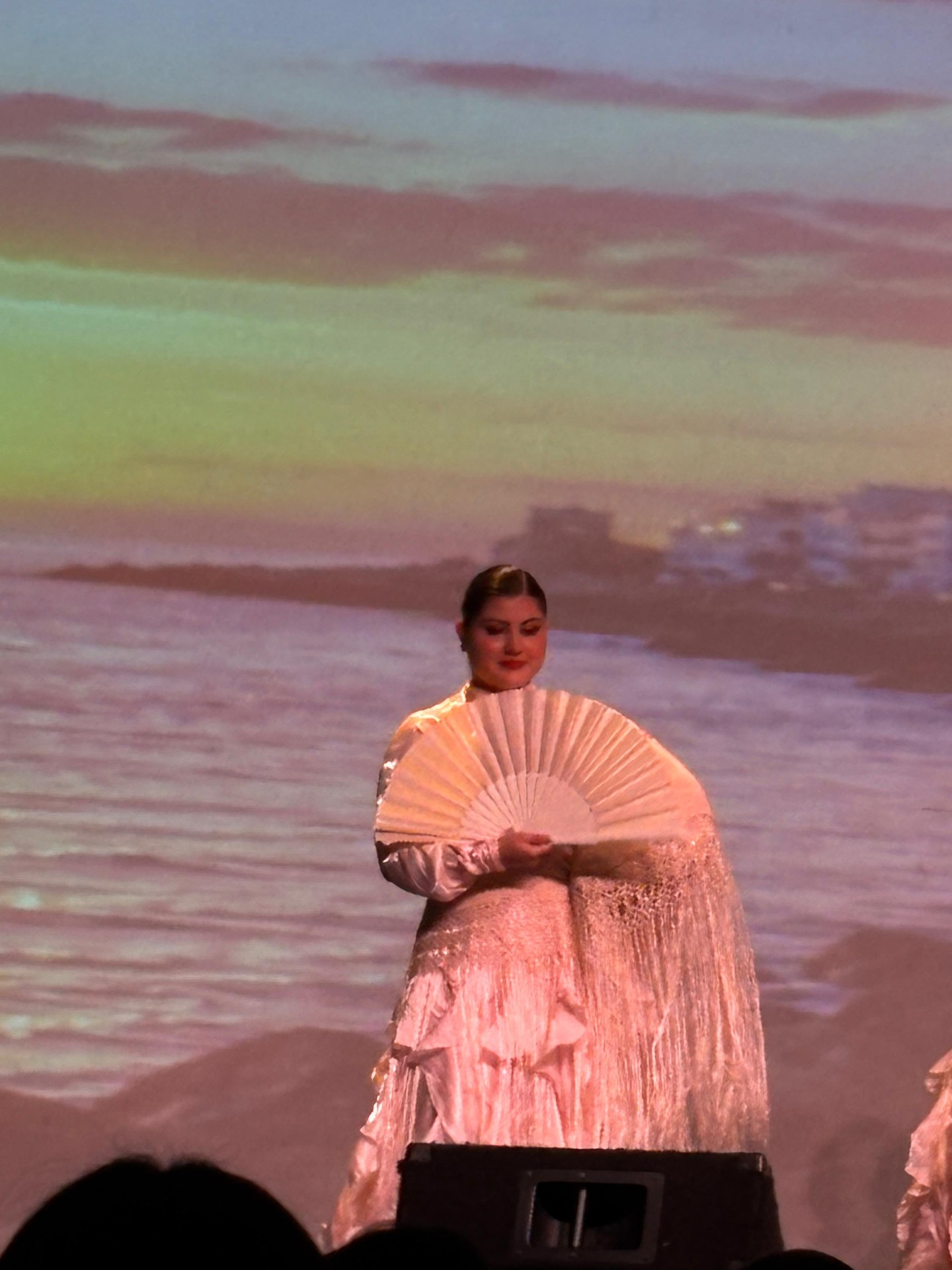 Mia with white fan, sea backdrop